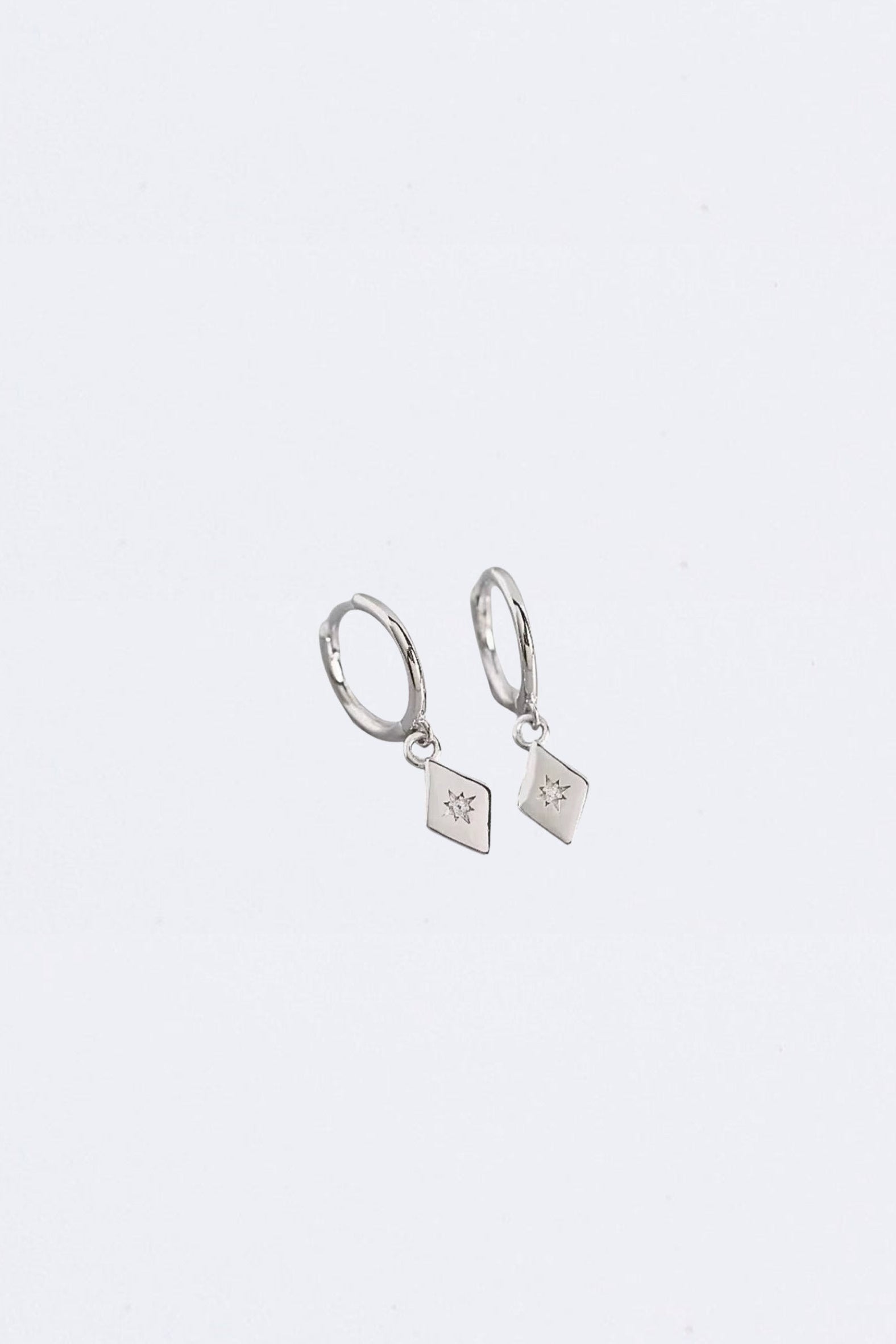 Pair of silver hoop earrings with square charms on a light gray background
Maraux Petite Diamond-Shaped Huggie Earrings Maraux Jewellery