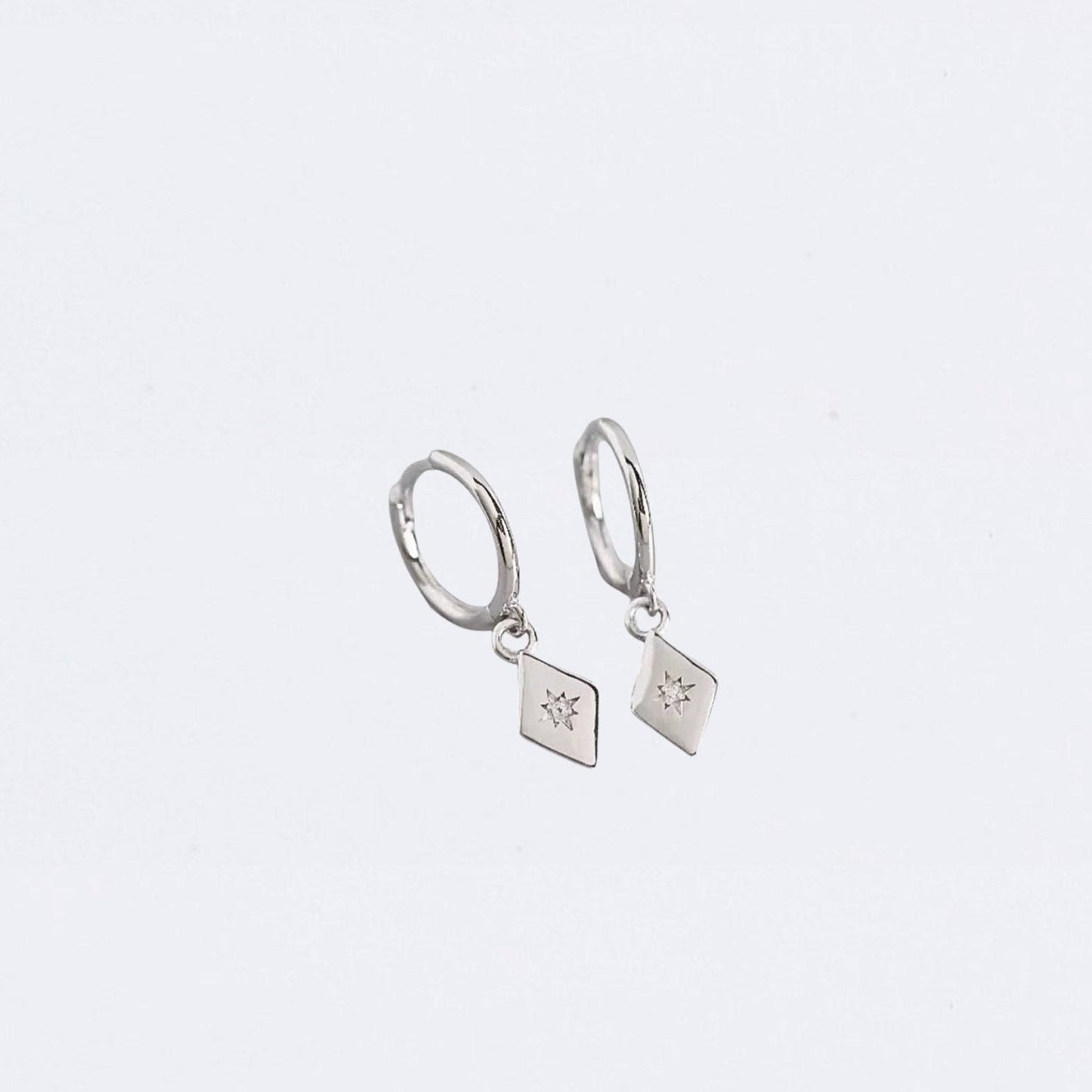 Pair of silver hoop earrings with square charms on a light gray background
Maraux Petite Diamond-Shaped Huggie Earrings Maraux Jewellery