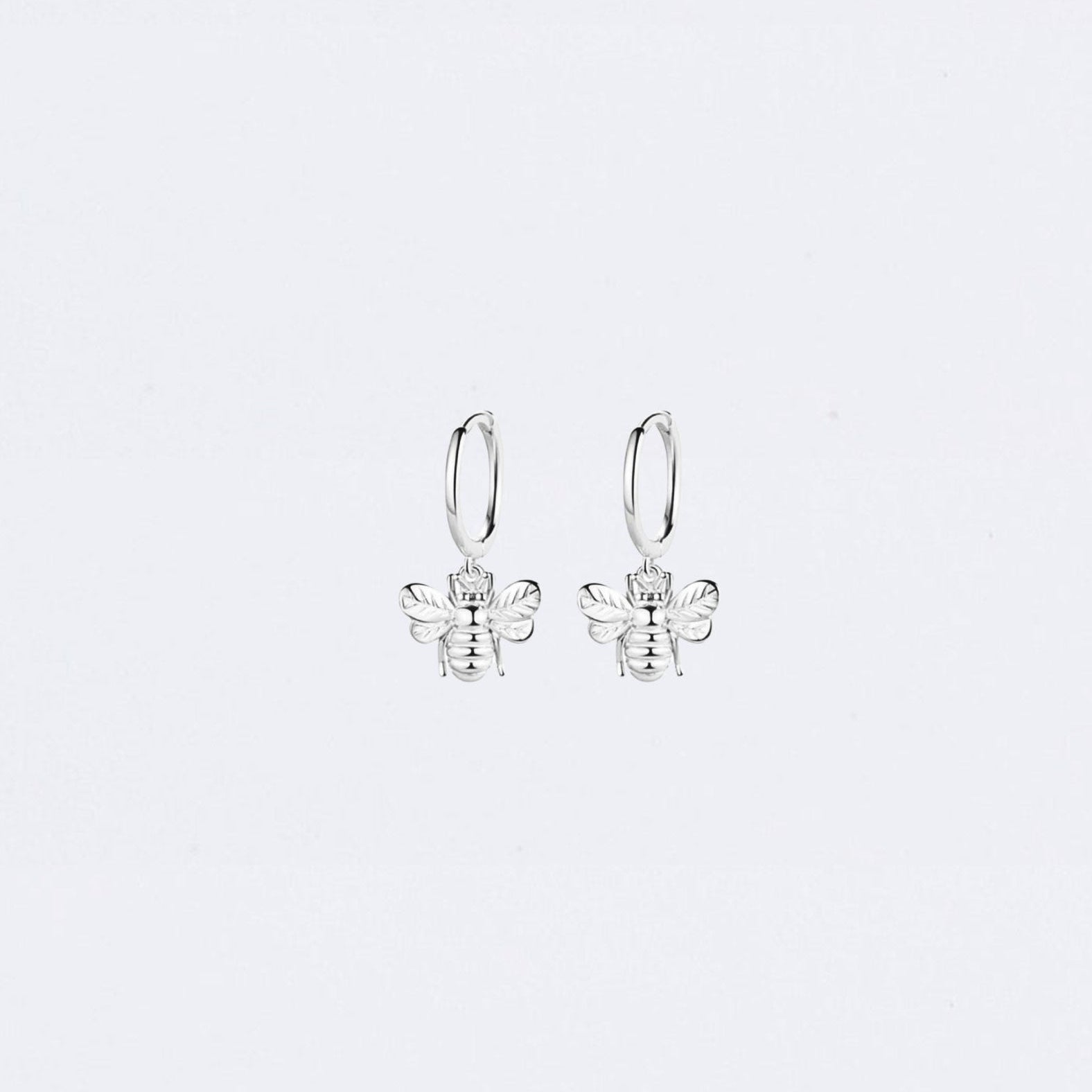 Silver bee-shaped earrings on a light gray background