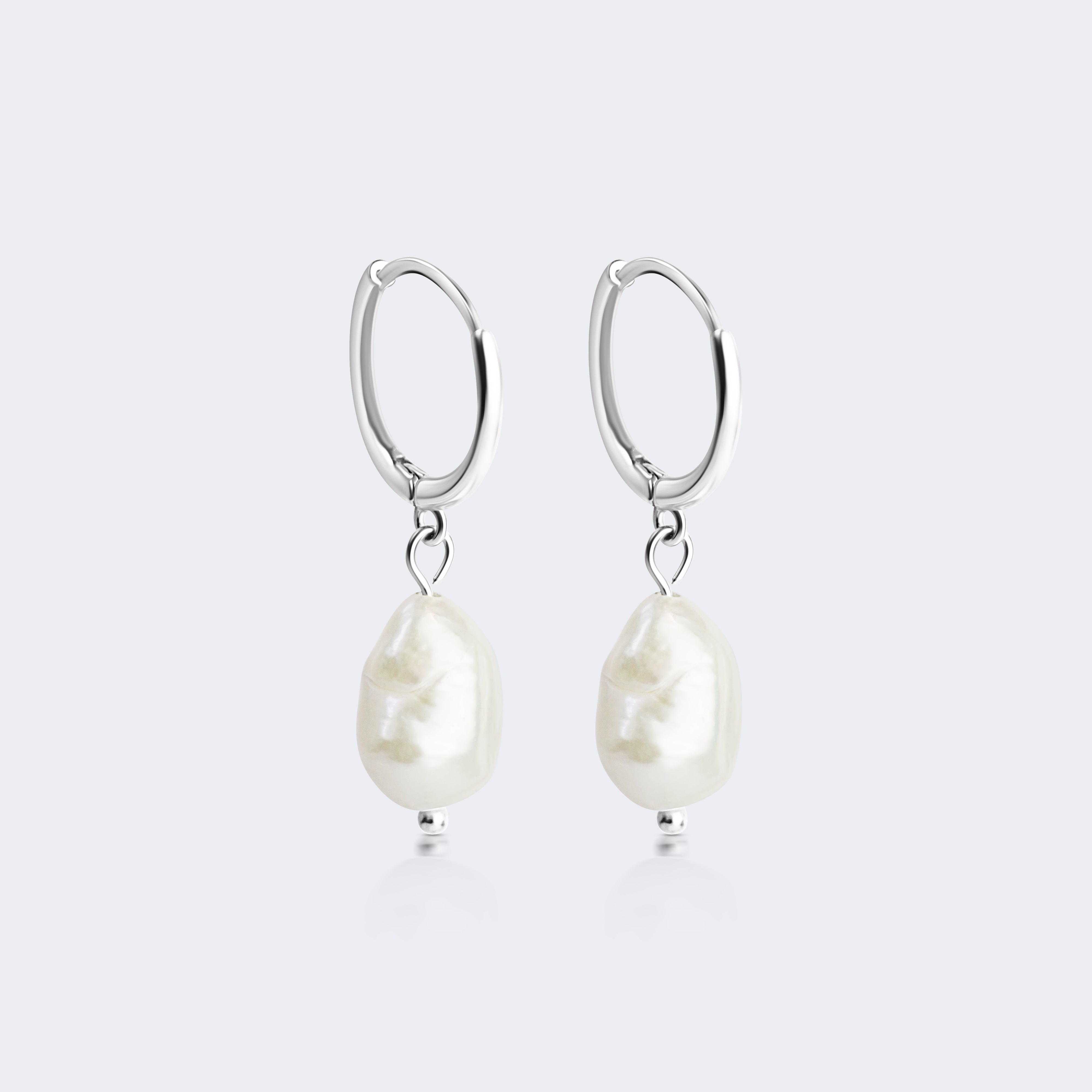 A pair of silver hoop earrings with dangling baroque-style white pearls, shown against a light gray background.