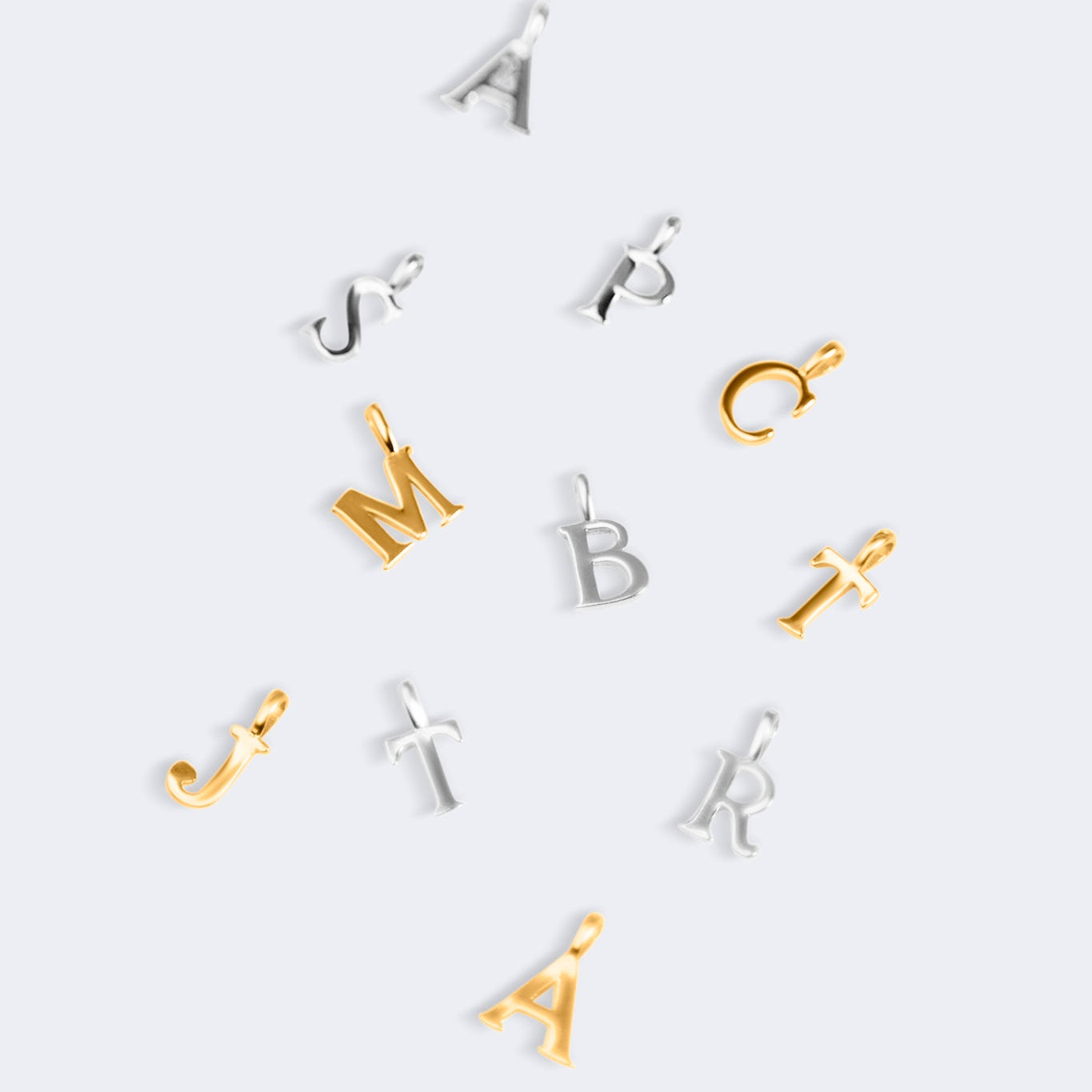 Set of gold and silver letter pendants on a white background