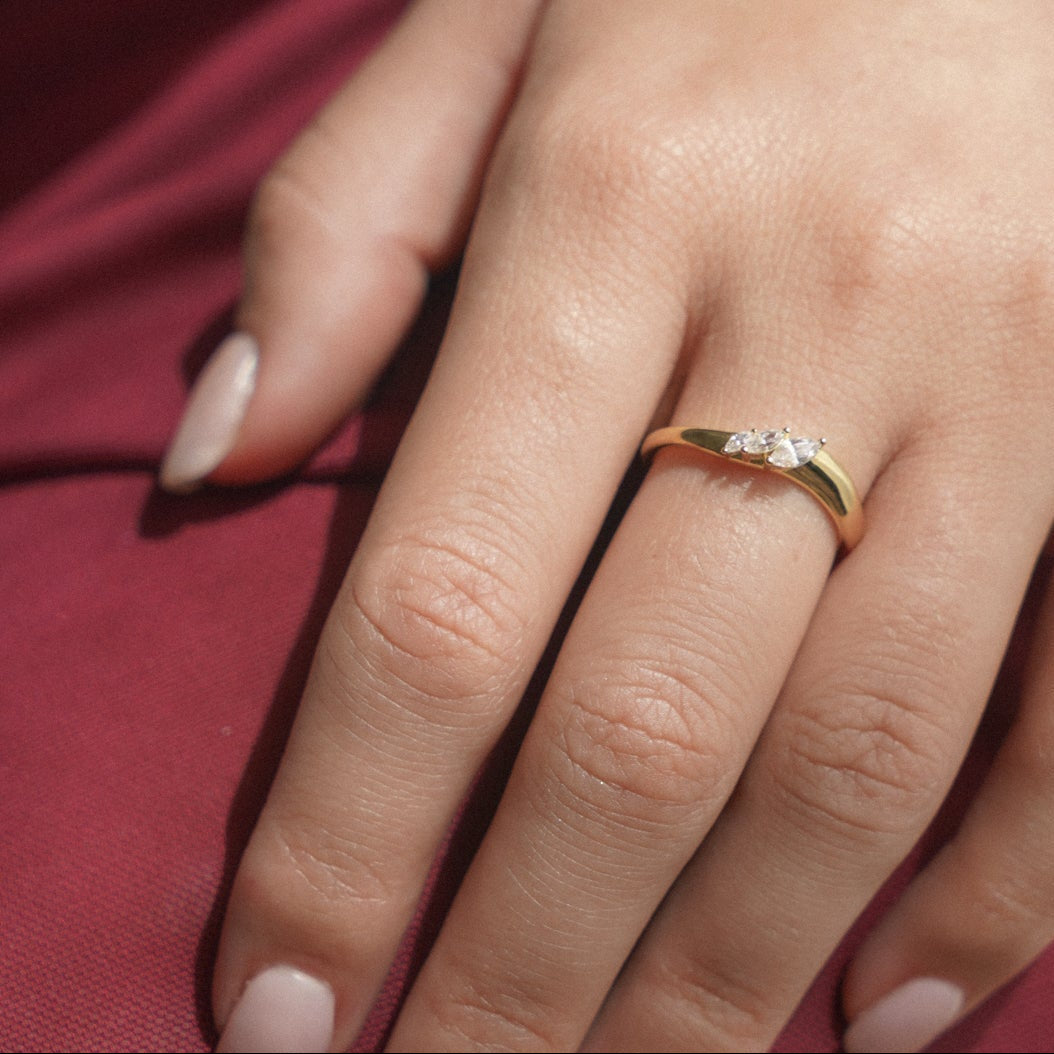 Sarina ring worn on a hand, slim wave shaped band