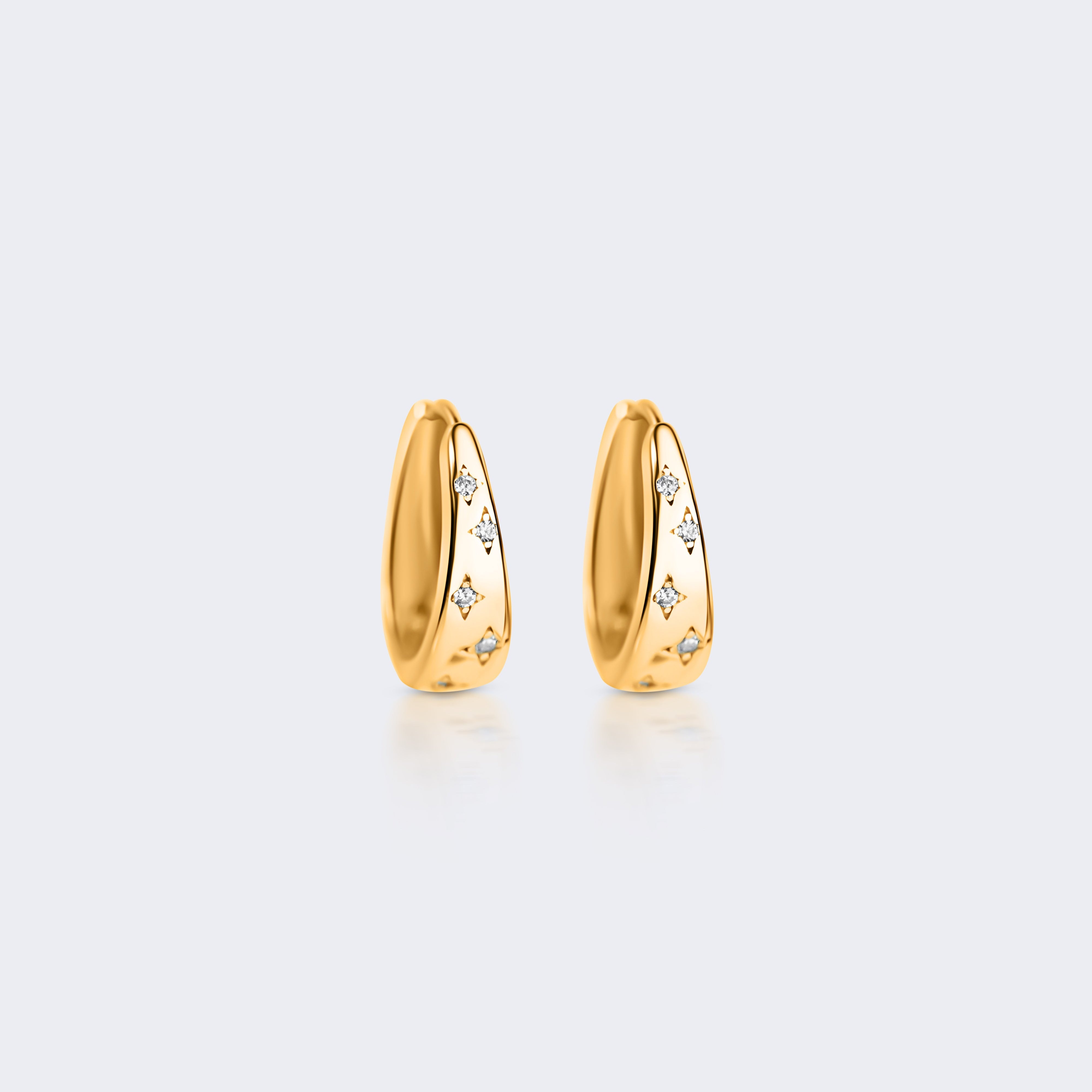 A pair of small gold huggie hoop earrings with tiny clear stones set along the front, displayed on a light gray background.
