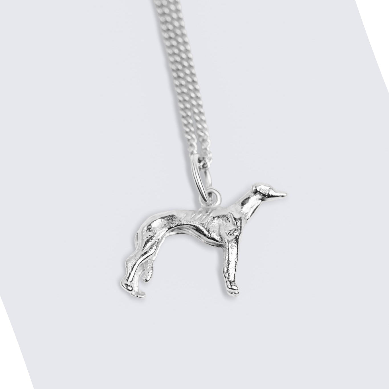 A silver chain necklace featuring a polished silver pendant shaped like a slender greyhound dog