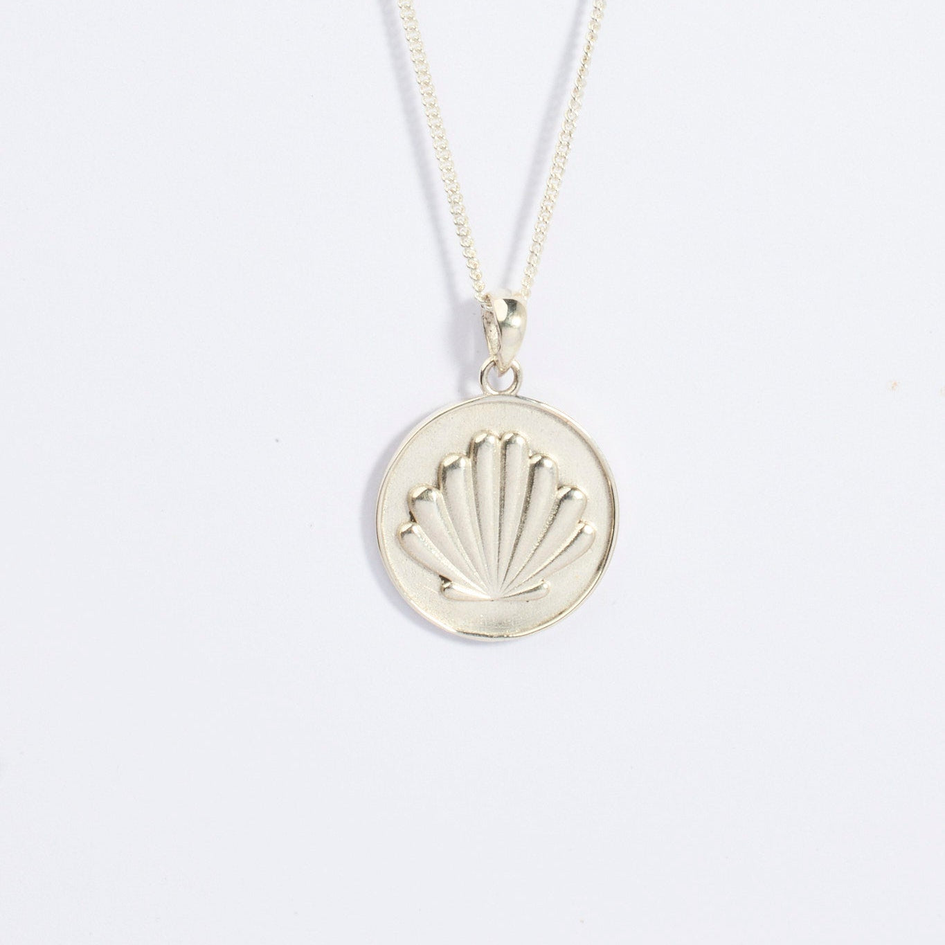 Silver Camino shell necklace with a scallop shell shaped pendant on a light gray background