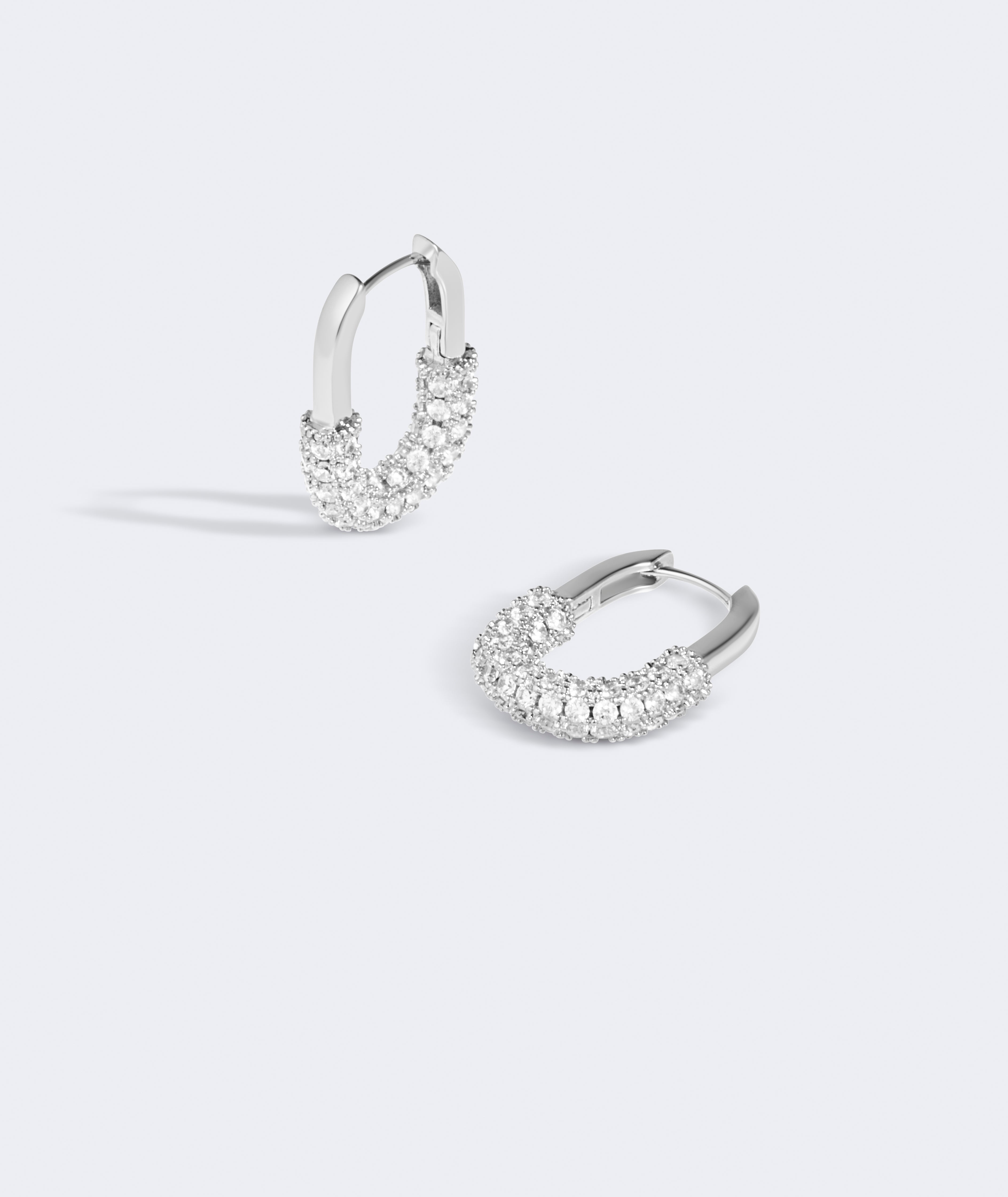 Pair of silver hoop earrings with clear gemstones on a light gray background