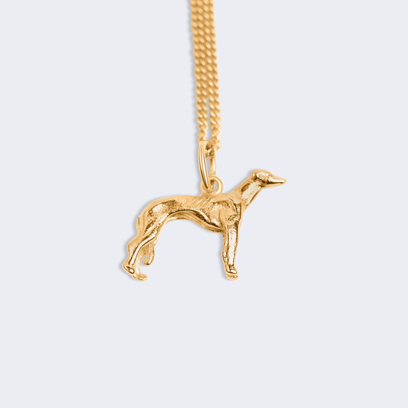 A gold-tone chain necklace featuring a detailed greyhound pendant